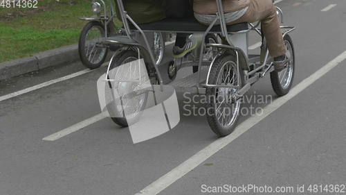 Image of View of legs of man cycling in city park area.