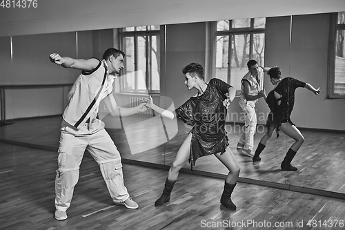 Image of beautiful couple dancing bachata in dance studio