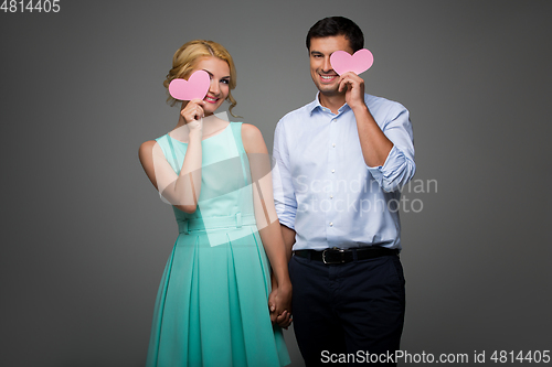 Image of Beautiful couple holding pink hearts