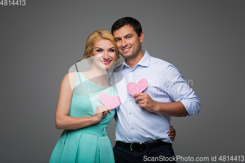 Image of Beautiful couple holding pink hearts