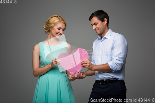 Image of Beautiful couple holding pink broken heart