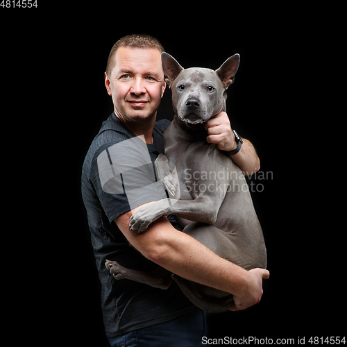 Image of man holding thai ridgeback dog