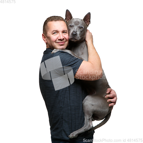 Image of man holding thai ridgeback dog