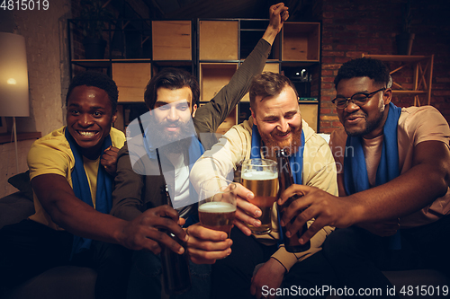 Image of Group of friends watching TV, sport match together. Emotional fans cheering for favourite team, watching on exciting game.