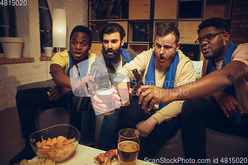 Image of Group of friends watching TV, sport match together. Emotional fans cheering for favourite team, watching on exciting game.