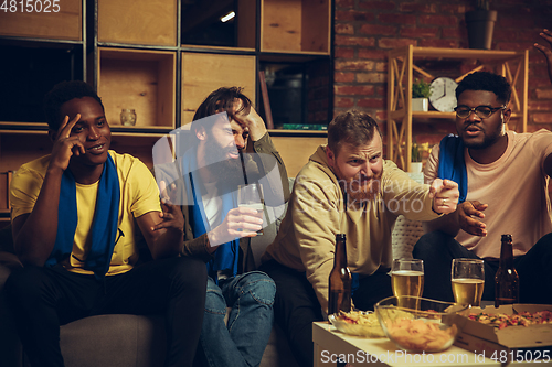 Image of Group of friends watching TV, sport match together. Emotional fans cheering for favourite team, watching on exciting game.