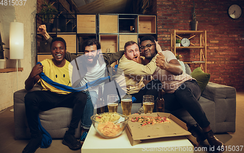 Image of Group of friends watching TV, sport match together. Emotional fans cheering for favourite team, watching on exciting game.