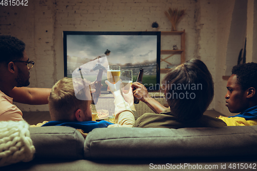 Image of Group of friends watching TV, sport match together. Emotional fans cheering for favourite team, watching on exciting game.