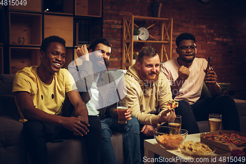 Image of Group of friends watching TV, sport match together. Emotional fans cheering for favourite team, watching on exciting game.