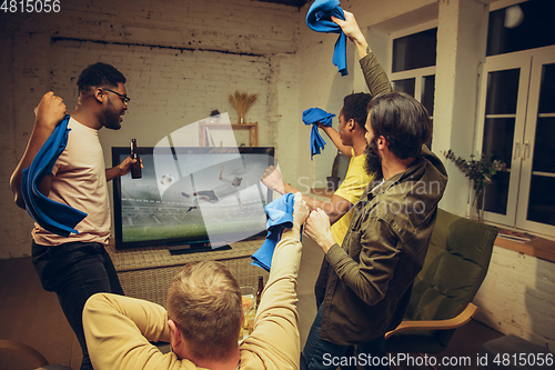 Image of Group of friends watching TV, sport match together. Emotional fans cheering for favourite team, watching on exciting game.