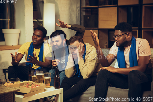 Image of Group of friends watching TV, sport match together. Emotional fans cheering for favourite team, watching on exciting game.