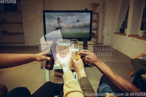 Image of Group of friends watching TV, sport match together. Emotional fans cheering for favourite team, watching on exciting game.