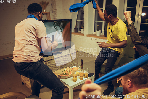 Image of Group of friends watching TV, sport match together. Emotional fans cheering for favourite team, watching on exciting game.