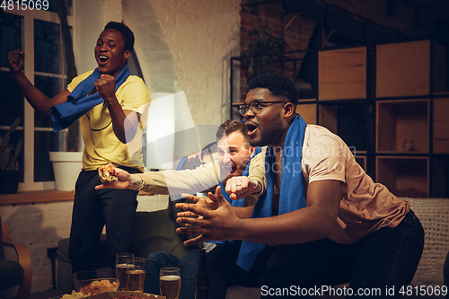 Image of Group of friends watching TV, sport match together. Emotional fans cheering for favourite team, watching on exciting game.