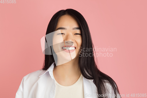 Image of Asian young woman\'s portrait on pink studio background. Concept of human emotions, facial expression, youth, sales, ad.