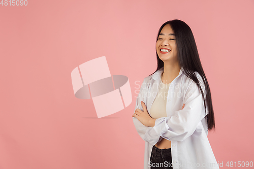 Image of Asian young woman\'s portrait on pink studio background. Concept of human emotions, facial expression, youth, sales, ad.