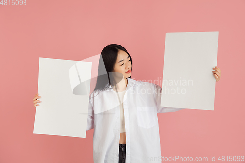 Image of Asian young woman\'s portrait on pink studio background. Concept of human emotions, facial expression, youth, sales, ad.