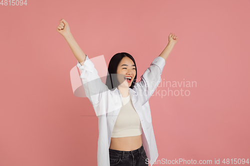 Image of Asian young woman\'s portrait on pink studio background. Concept of human emotions, facial expression, youth, sales, ad.