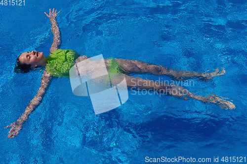 Image of teen girl relaxing near swimming pool