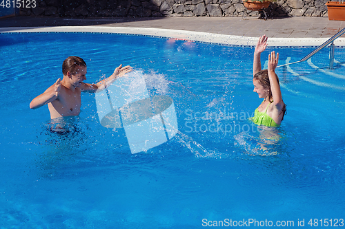 Image of boy and girl having fun in swimming pool