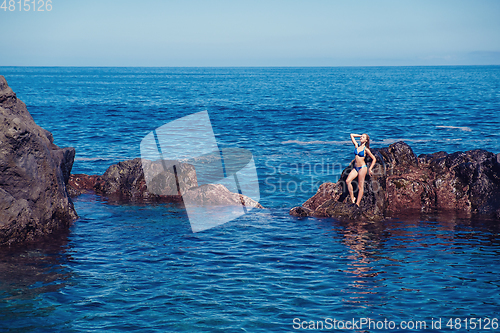 Image of beautiful girl resting in natural ocean swimming pool