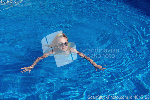 Image of teen girl relaxing near swimming pool