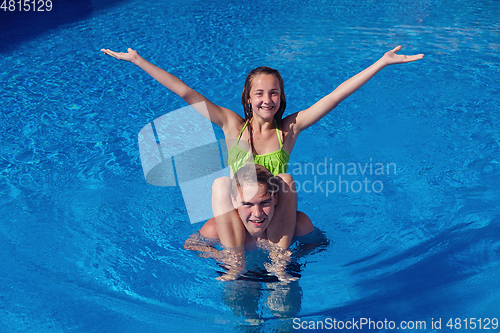 Image of boy and girl having fun in swimming pool
