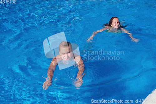 Image of boy and girl having fun in swimming pool