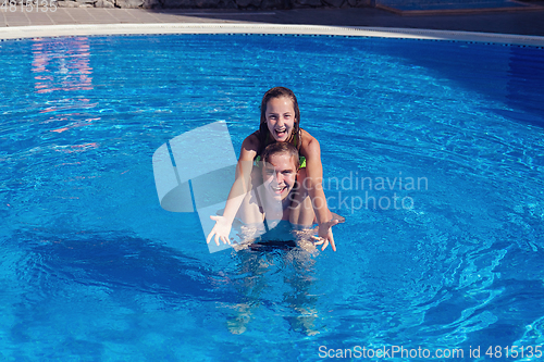 Image of boy and girl having fun in swimming pool