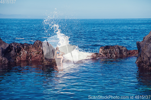 Image of beautiful girl resting in natural ocean swimming pool