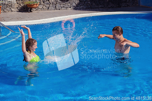 Image of boy and girl having fun in swimming pool
