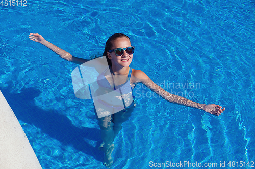 Image of teen girl relaxing near swimming pool