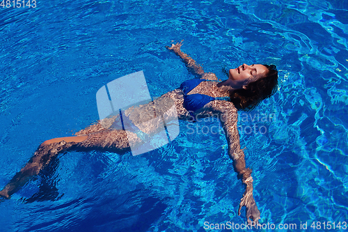 Image of teen girl relaxing near swimming pool