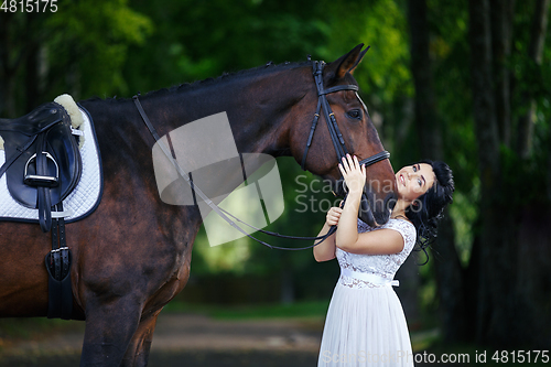 Image of beautiful girl in dress with horse