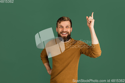 Image of Caucasian man\'s portrait isolated over green studio background with copyspace