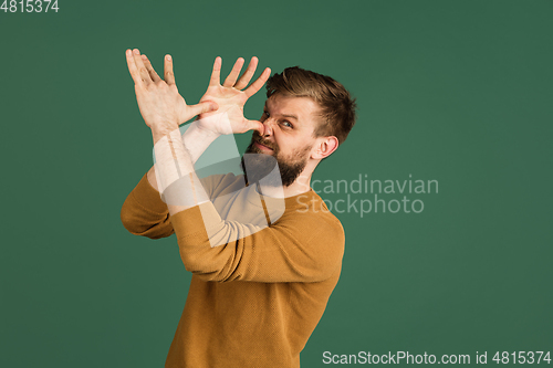 Image of Caucasian man\'s portrait isolated over green studio background with copyspace