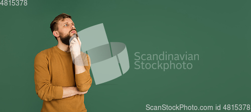 Image of Caucasian man\'s portrait isolated over green studio background with copyspace