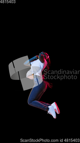 Image of African young woman\'s portrait on dark studio background in neon. Concept of human emotions, facial expression, youth, sales, ad.