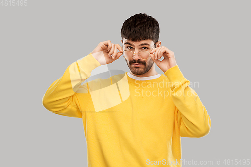 Image of young man in glasses and yellow sweatshirt