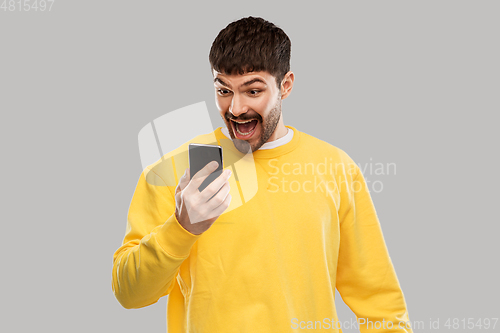 Image of happy smiling young man with smartphone