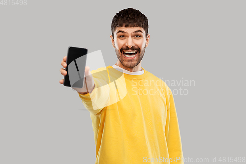 Image of happy smiling young man showing smartphone