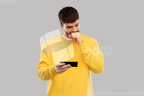 Image of puzzled young man with smartphone