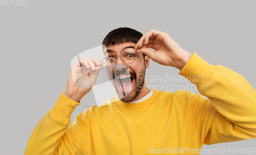 Image of goofy young man in glasses and yellow sweatshirt