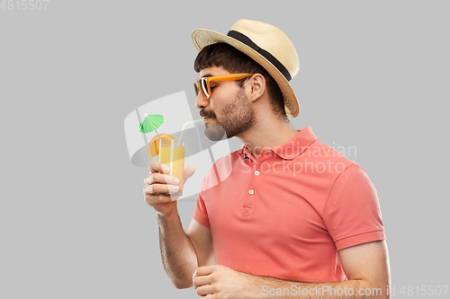 Image of man in straw hat drinking orange juice cocktail