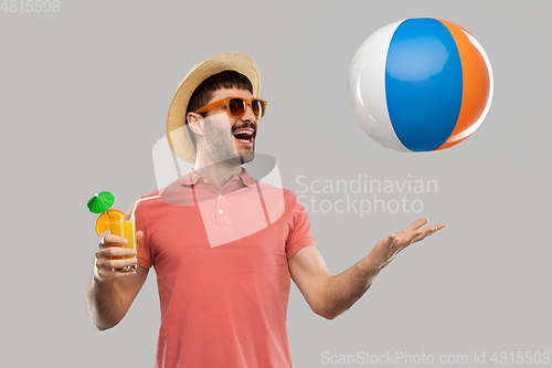 Image of happy man with orange juice and beach ball