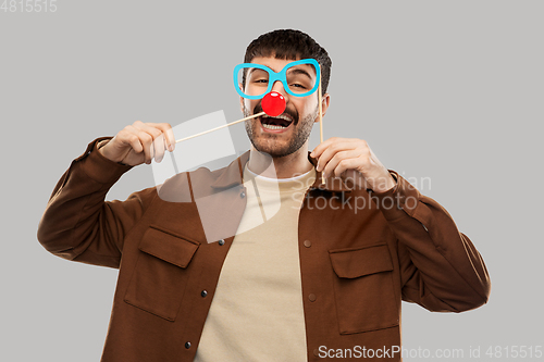 Image of happy smiling man with glasses and red clown nose