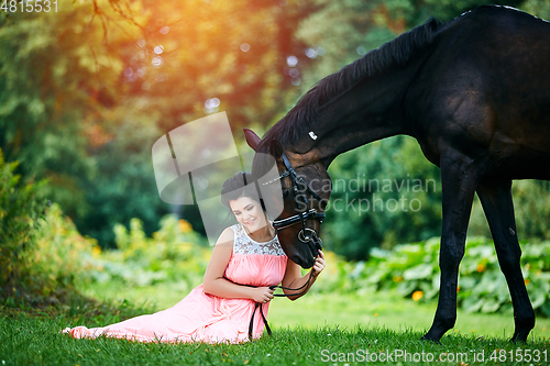 Image of beautiful girl in dress with horse