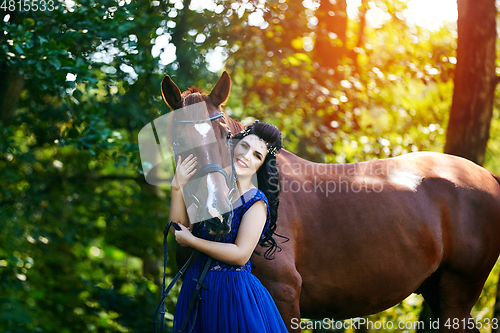 Image of beautiful girl in dress with horse