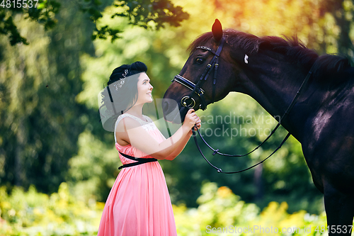 Image of beautiful girl in dress with horse