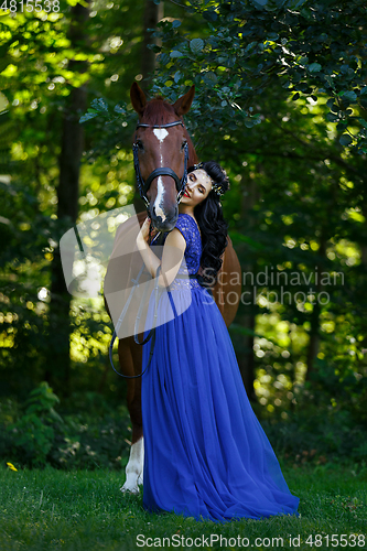 Image of beautiful girl in dress with horse